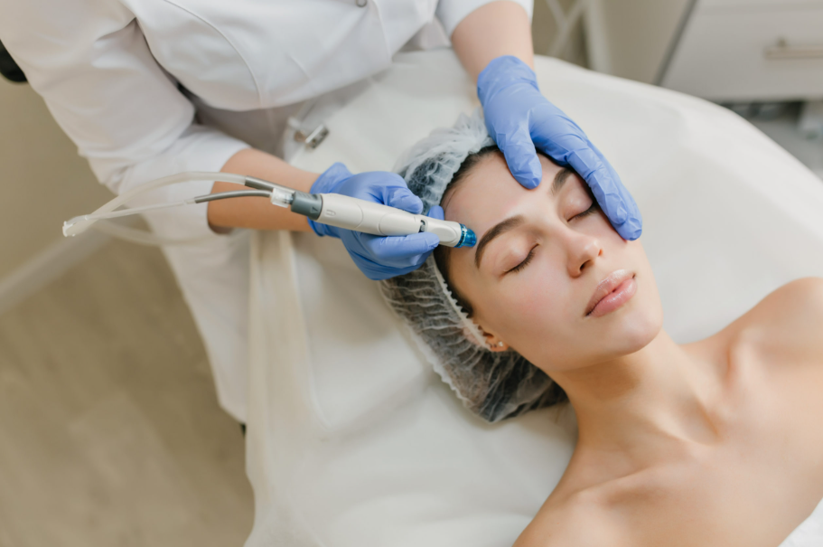 Hydrafacial treatment being performed on a woman’s face using a medical-grade device in a skincare clinic.