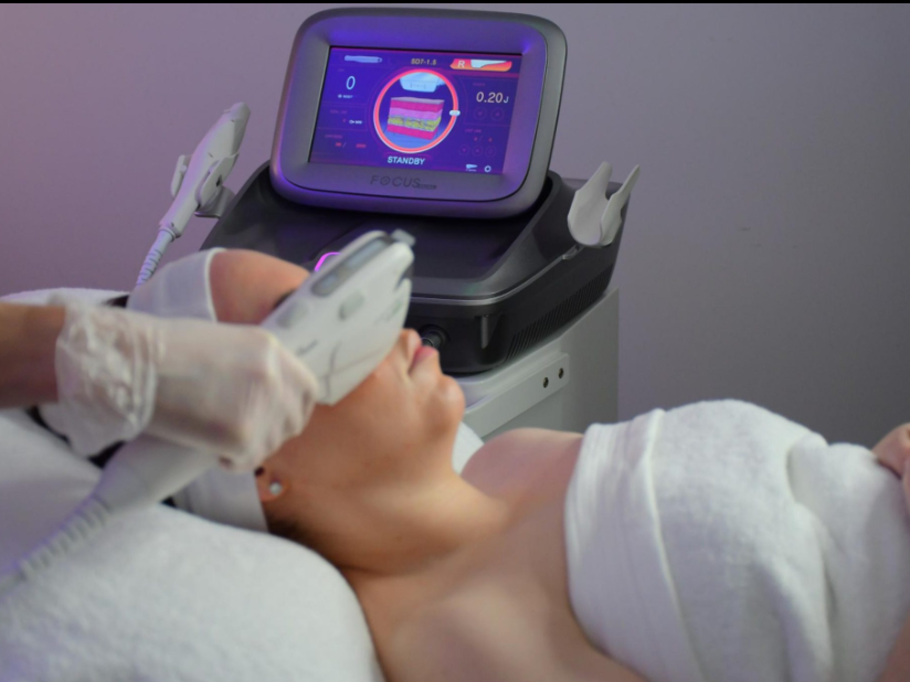 HIFU ultrasound machine being used during a non-surgical facial skin tightening treatment in a clinic.