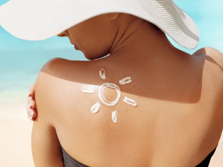 Applying sunscreen on the back to protect skin from sun damage.